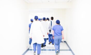 Zorgteam loopt door een ziekenhuisgang - roosteren en werkgeluk in de zorg